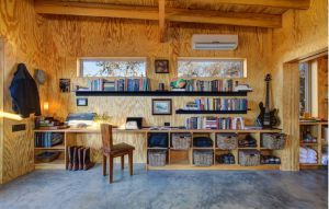 La micro vivienda cuenta con una sala de estar y una oficina con un amplio escritorio y librero La micro vivienda cuenta con una sala de estar y una oficina con un amplio escritorio y librero