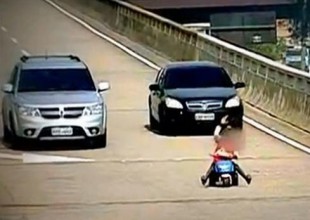 Niño de ocho años anda en triciclo por autopista