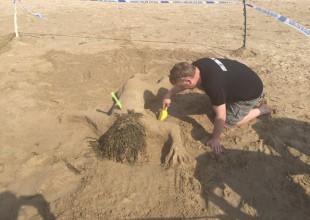 Policías ganan concurso de castillos de arena recreando una escena de un crimen