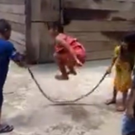 Niños valientes saltan la cuerda usando una serpiente