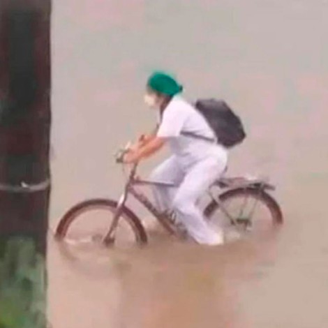 Enfermera cruza calles inundadas en bici al regresar del trabajo