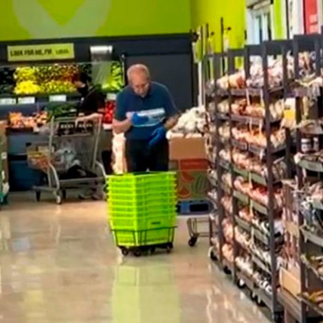 Empleado limpia con saliva los cestos de un supermercado